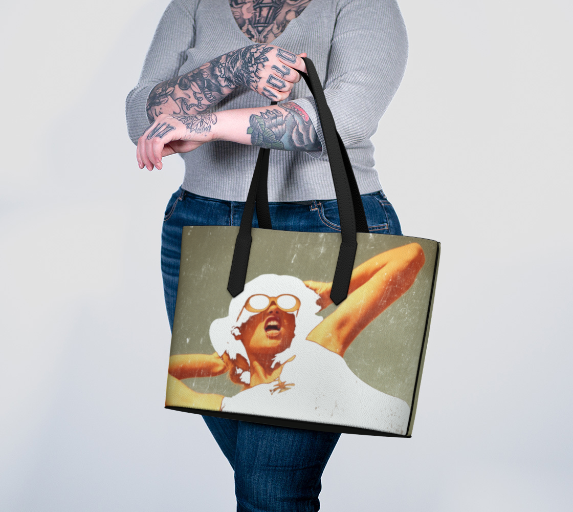 woman holding vegan leather tote bag with the image of a fashion model artistically rendered