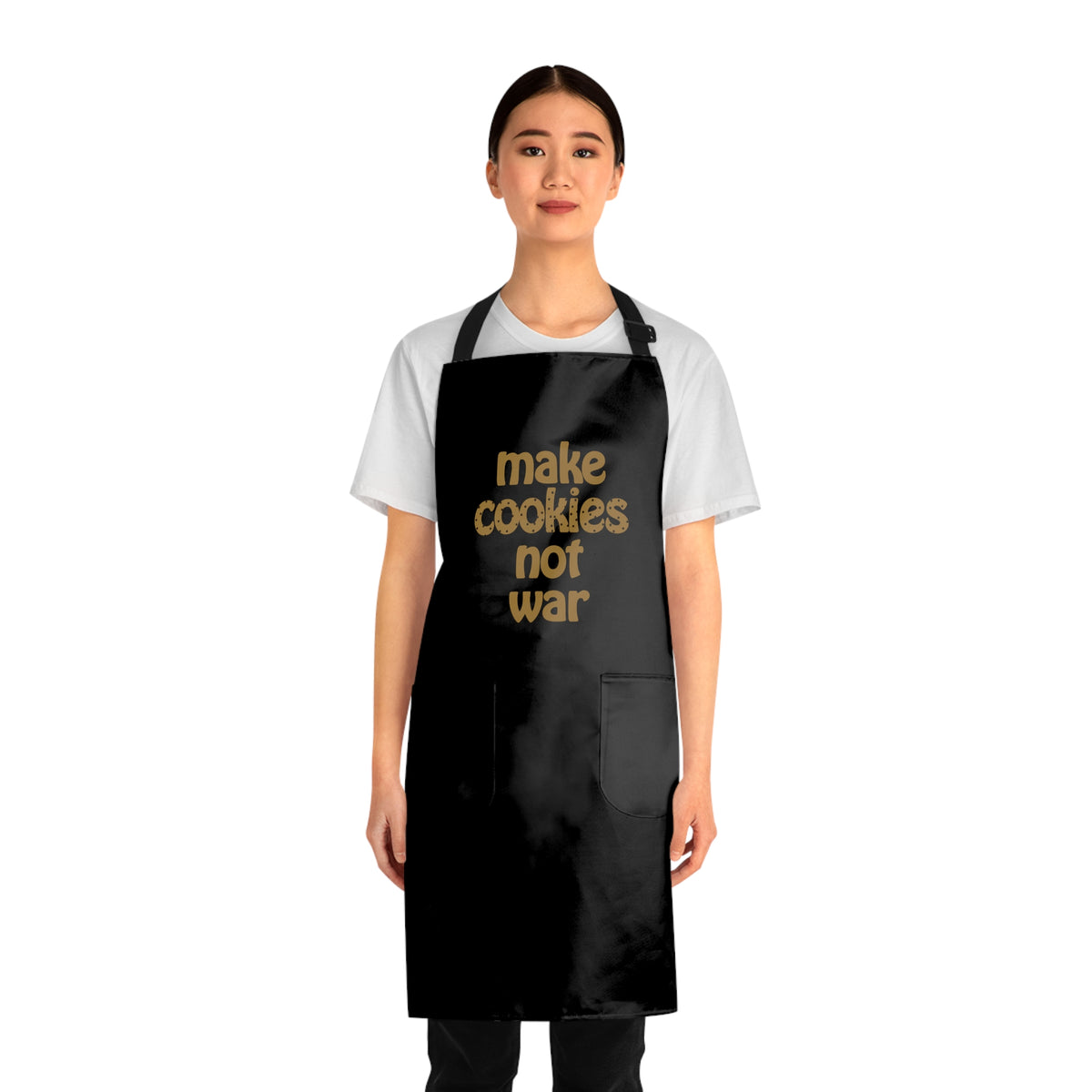 front view of a girl wear a black apron with two pockets that says "make cookies not war"