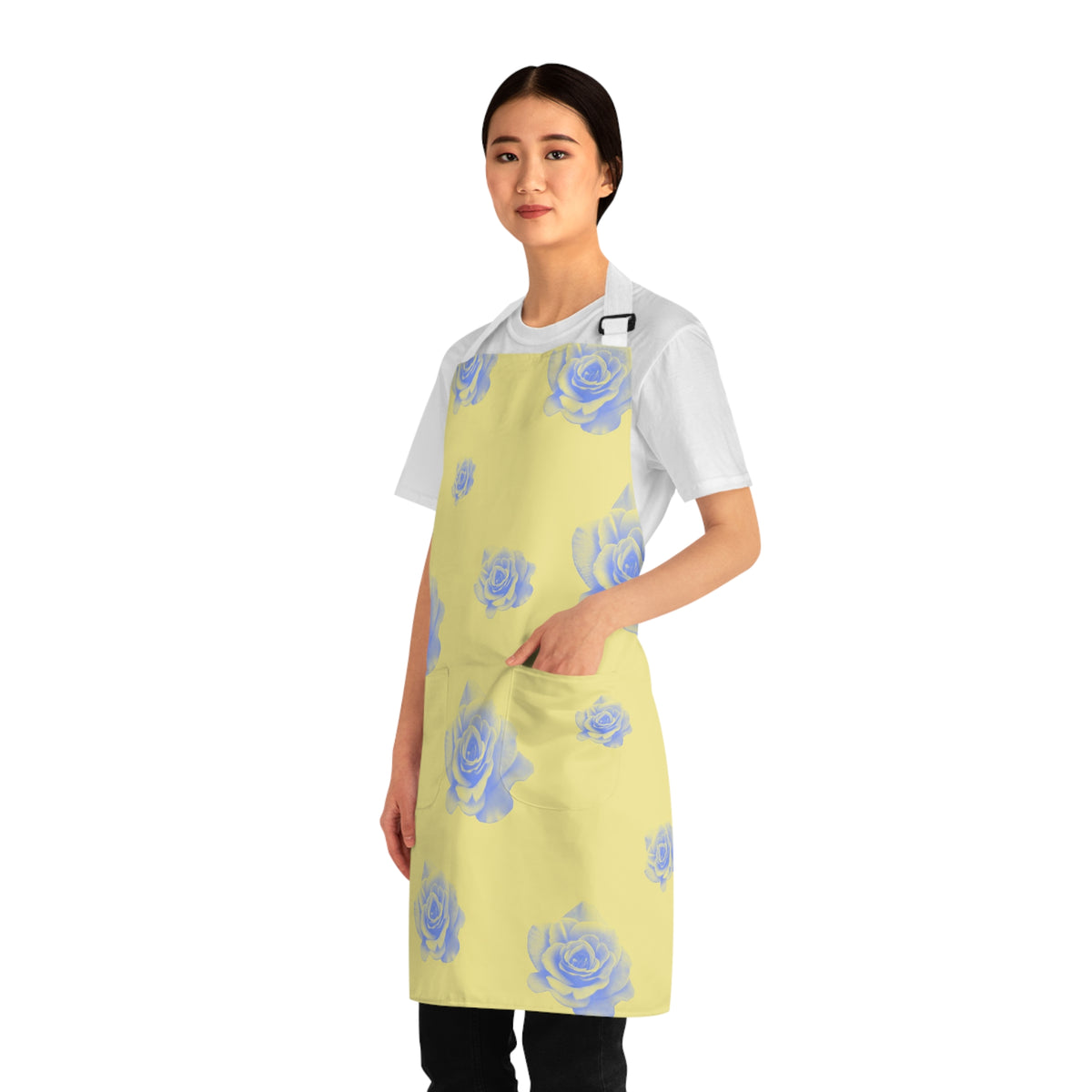 side view of girl wearing a grilling apron with a yellow and blue rose pattern on it and white straps with her left hand in apron pocket