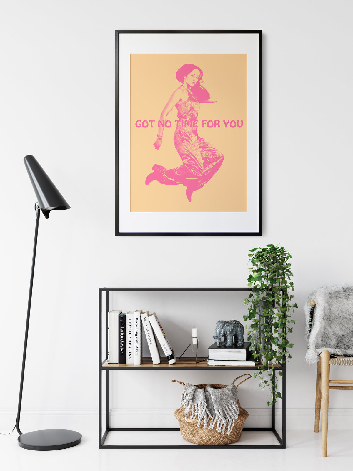 interor room view of muted yellow fine art poster print of a young woman jumping in the air with the words Got NO Time For You both the woman and words are pink