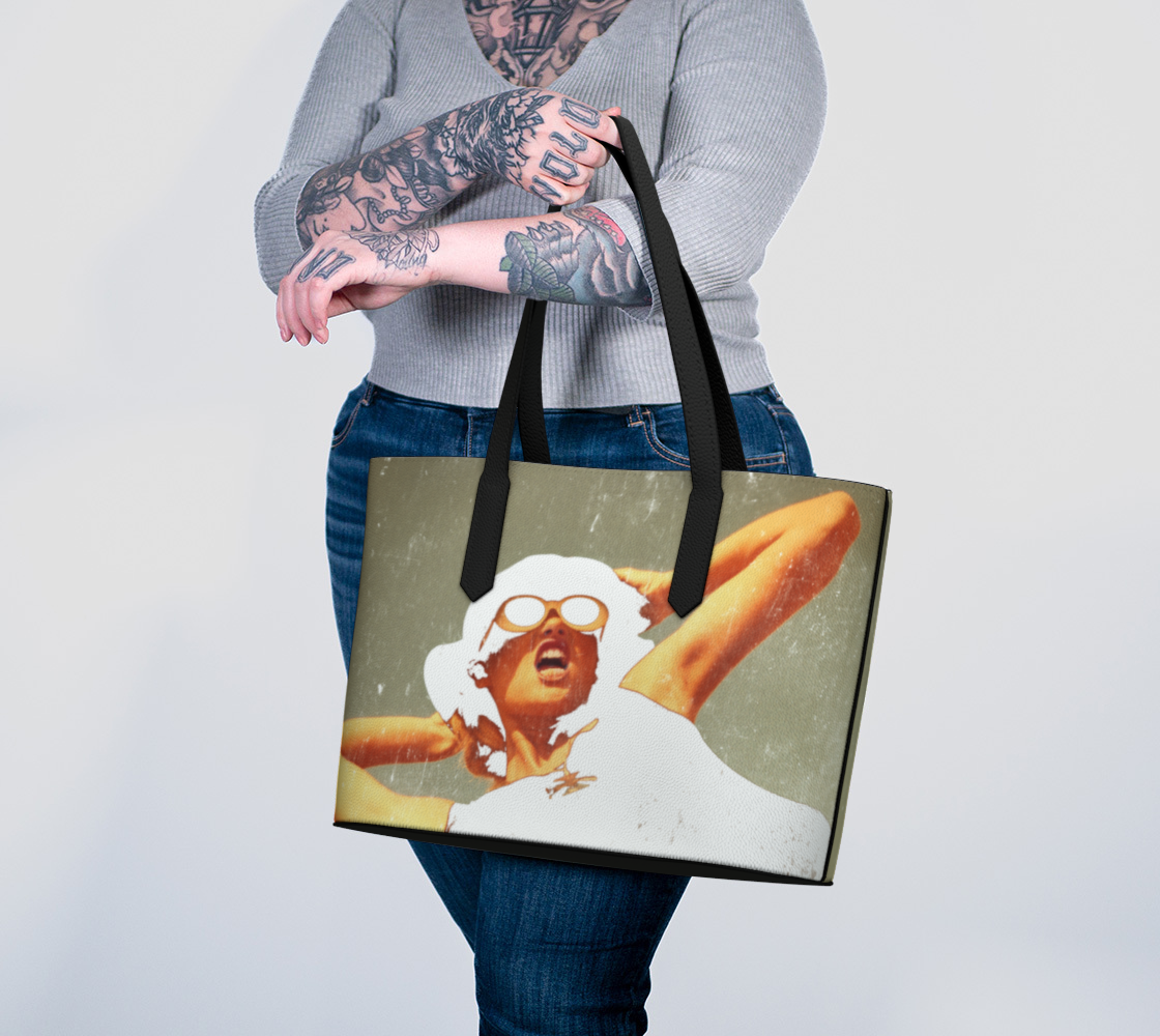 woman holding vegan leather tote bag with the image of a fashion model artistically rendered 
